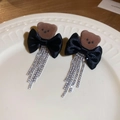 Detalle de pendientes de oso con lazo negro y borlas de pedrería plateada brillante - Borla de Oso Marrón
