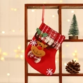Calza natalizia rossa con renna di peluche e campanello appesa a un supporto di legno - Cervo