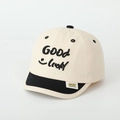 Dettaglio del cappellino beige con ricamo Good Luck nero e motivo con faccina sorridente - 52cm (2-5 Anni) / Bianco Sporco