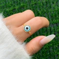 Detail showing handmade gold wire wrapped ring featuring a blue evil eye stone bead - 01 Gold + Blue (Evil Eye)