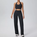 Detail eines schwarzen Yoga-Sets mit Neckholder-Top und weit geschnittener Sporthose - S / Schwarz