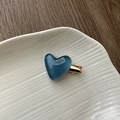 Macro detail of jelly blue heart hair clip with gold metal base on ceramic tray - Jelly Heart Hair Clip-Blue