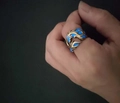 Detail eines Drachenmusters-Ring mit blau leuchtender Einlage bei schwachem Licht - Einstellbar Offen / Antik Bronze + Blaues Leuchten
