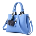Light blue faux leather handbag for women featuring quilted patterns and fuzzy pompom charms - Light Blue