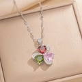 Detailopname van een klaverhanger met rode, groene en roze hartstenen aan een zilveren ketting - Zilveren Ketting / Zilver