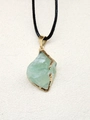 Détail d'un pendentif en pierre naturelle verte irrégulière avec bords dorés polis - Aventurine Verte