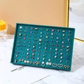 Dark green velvet jewelry tray displaying rings and earrings in a luxury setting - 100 Slots Ring Tray
