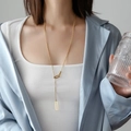 Minimalist gold-tone long rectangle geometric pendant necklace for women shown on model - Hollow Square / Gold