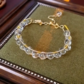 Dettaglio bracciale con occhio di tigre e cristallo con filo dorato e catena regolabile - Bianco