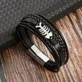 Dettaglio del bracciale multistrato in pelle nera con lisca di pesce e chiusura in metallo - Nero + Argento