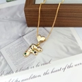 Macro detail of gold letter F pendant with colorful zircons and heart clasp on box chain - Letter F