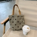 Close-up of corduroy tote bag with brown polka dots and magnetic closure on outdoor chair - Grey Polka Dot