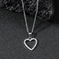 Elegante Herz-Halskette mit funkelnden Kristallen auf schwarzem Stein Hintergrund - Silber