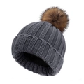 Bonnet d'hiver en tricot gris foncé avec un pompon marron moelleux sur fond blanc uni - Gris / Enfants