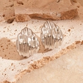 Boucles d'oreilles argentées plissées en forme de coquille sur pierre beige - Coquille Argentée