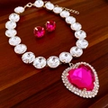 Detail of pink heart crystal necklace and matching studs on a wood tray - 2-Piece Purple Heart Necklace Set