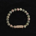 Detailed macro view of natural unakite stone bracelet with bronze Active engraved plate - Unakite-Active