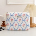 Close-up of quilted floral cosmetic bag with blue bows, pink roses and cream zipper - Blue Rose Medium Cosmetic Bag