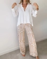 Detail van witte blouse en wijde broek met bruine geometrische print op model - S / Boven- En Onderstuk / Khaki