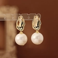 Dettaglio macro di orecchini vintage con perle e piastra dorata irregolare e perla bianca - Perno in Argento-Oro-Bianco