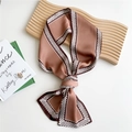 Mocha brown skinny silk scarf tied as a bow with geometric border on a wooden tray - Woven Chain Brown