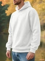 Close-up of men's white cable knit hoodie showing thick jacquard texture and ribbed cuffs - White