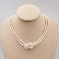 Elegante collana di perle bianche a doppio filo con nodo centrale su supporto per gioielli - Collana / Bianco