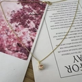 Champagne pink round zircon pendant on a gold necklace with sparkling white stones - November Orange