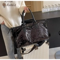 Detailed view of a large black sequin travel duffel bag with sturdy handles and shoulder strap. - Black