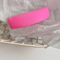 Detail shot of a neon pink fabric rectangular hair clip on a white grid basket - Barbie Pink
