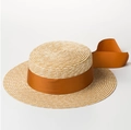 Close-up of natural straw boater hat featuring fine woven texture and rust red ribbon trim - 7cm Caramel Ribbon