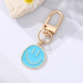 Light blue enamel smiley face keychain with gold-plated alloy lobster clasp and floral decor - Lake Blue