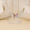 Elegant gold butterfly necklace with purple gradient wings and zircon on a crystal glass - Light Purple