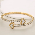 Gouden roestvrijstalen armband met witte hartschelpen en glanzende zirkonia inlegwerk - Goud