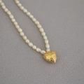 Close-up of freshwater pearl necklace featuring a textured golden heart-shaped coin pendant - Small Hammered Heart