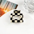 Close-up of a 5cm square black and white checkered hair claw clip on a white plate - Cube / Red and Blue Plaid