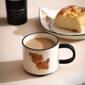 Close-up of ceramic puppy mug with 3D brown dog relief and cozy breakfast background - 300ml / Black