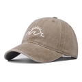 Close-up of white sun and wave embroidery on a washed tan cotton baseball cap - Khaki