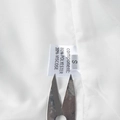 Detail of white vest lining showing the size S and polyester blend fabric care label - S / White