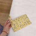 Detail view of yellow floral cotton pouch with matching wrist strap on white fabric - Light Yellow Floral