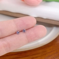 Minimalist silver stud earrings featuring small round purple zircons on finger - Vertical Prong No.3 / Purple