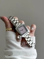 Détail de la montre carrée à cadran lavande avec bracelet en métal argenté au poignet - Bracelet en Acier Argent Violet