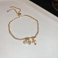 Detalle de una pulsera dorada ajustable con cruz de circón, estrella y perla blanca - Estilo Perla Estrella Cruz Dorada / Dorado