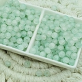 Macro detail of 6mm light green ice-cracked glass beads in a ceramic dish for DIY jewelry - Jade Texture Cyan (6mm)