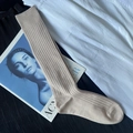 Beige ribbed knit mid-calf sock shown in a professional flat lay on a textured background - Calf-length Apricot