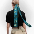 Detail view of a blue oil painting style silk scarf tied around a ponytail on white background - Almond Blossom (Color 2)