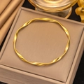 Gold Mobius twisted bangle displayed on luxury jewelry box with elegant silk fabric - Gold Mobius Twisted Bangle