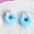 Detail view of matte resin bow donut accessories with macaron color and sprinkles - Small Bow - Blue Base + Pink