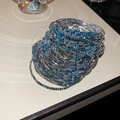 Macro shot of layered blue and white rhinestone bracelets with gradient crystal effect - Silver-Blue