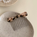 Pink leopard print acetate bow hair comb with metal teeth on a ceramic plate - Light Tortoiseshell
